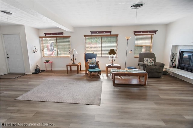 living room featuring hardwood / wood-style floors, plenty of natural light, and beamed ceiling