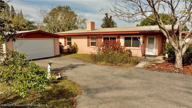 single story home featuring a garage and an outbuilding