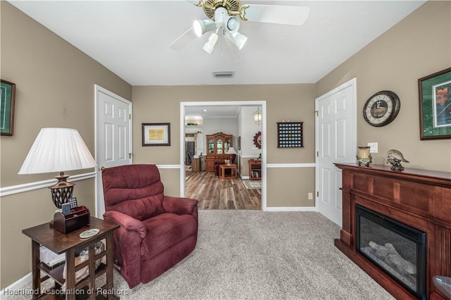 living area featuring carpet and ceiling fan