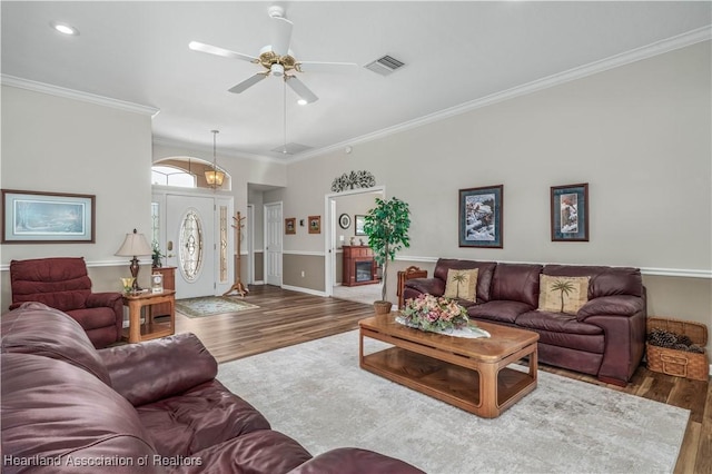 living room featuring ceiling fan, crown molding, and dark wood-type flooring