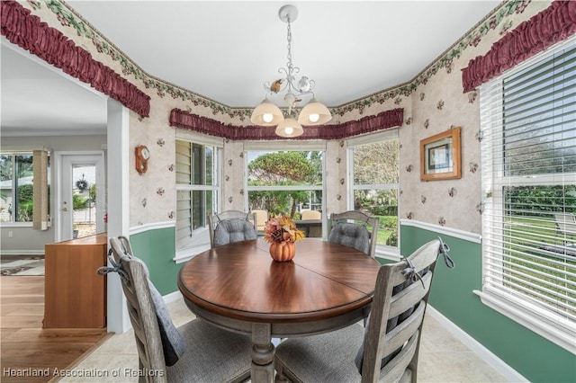 dining space with a chandelier, crown molding, and light tile patterned flooring