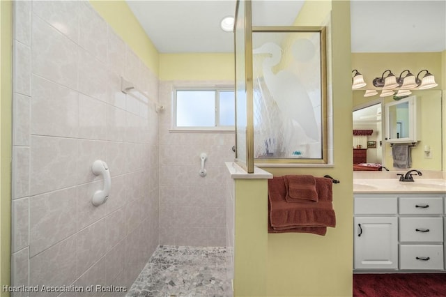 bathroom with tiled shower and vanity