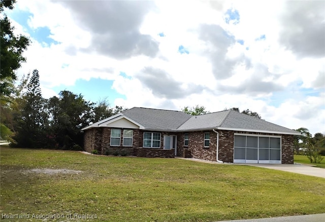 ranch-style home featuring a garage, brick siding, driveway, roof with shingles, and a front yard