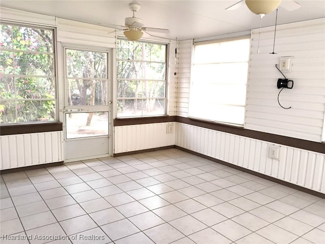 unfurnished sunroom with a ceiling fan and radiator