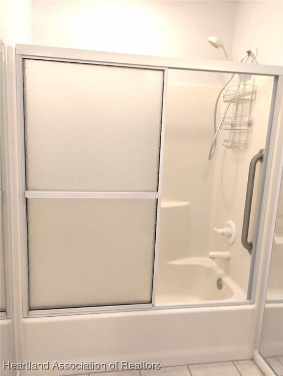 bathroom featuring enclosed tub / shower combo and tile patterned flooring