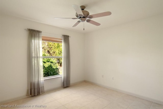 empty room featuring ceiling fan, baseboards, and light tile patterned floors