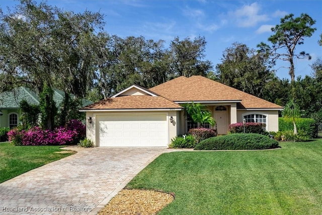 ranch-style house with a front lawn, decorative driveway, an attached garage, and stucco siding