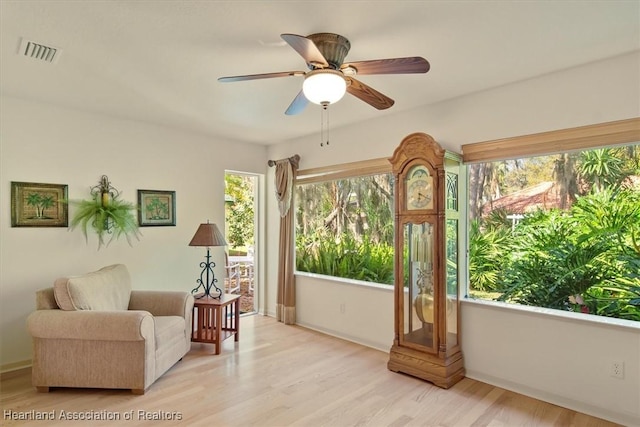 sitting room with light wood finished floors, visible vents, and a ceiling fan