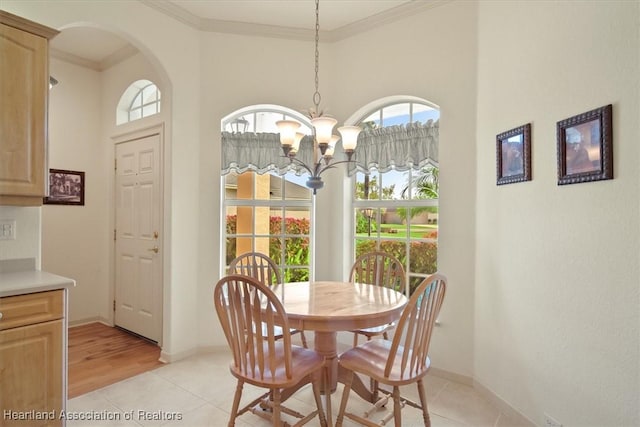 dining area featuring a chandelier, light tile patterned floors, baseboards, and crown molding