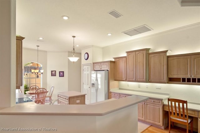 kitchen featuring ornamental molding, a center island, hanging light fixtures, light countertops, and white fridge with ice dispenser