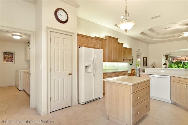 kitchen with white appliances, a center island, crown molding, washing machine and dryer, and light tile patterned flooring