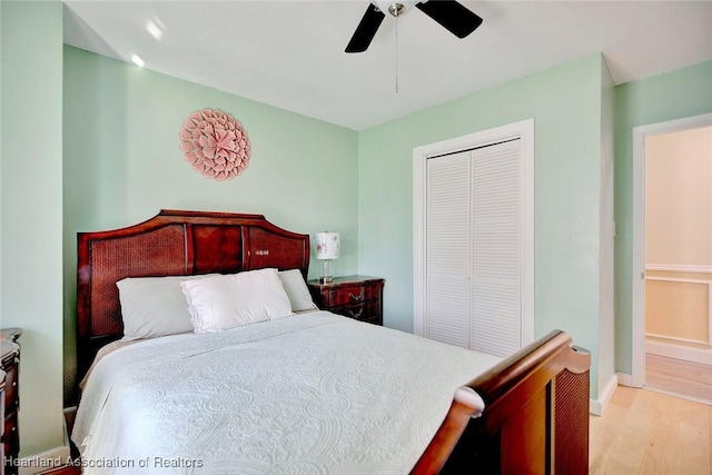 bedroom with a closet, light hardwood / wood-style flooring, and ceiling fan