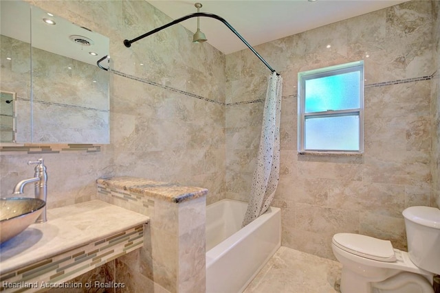 full bathroom with sink, shower / tub combo, tile walls, and toilet