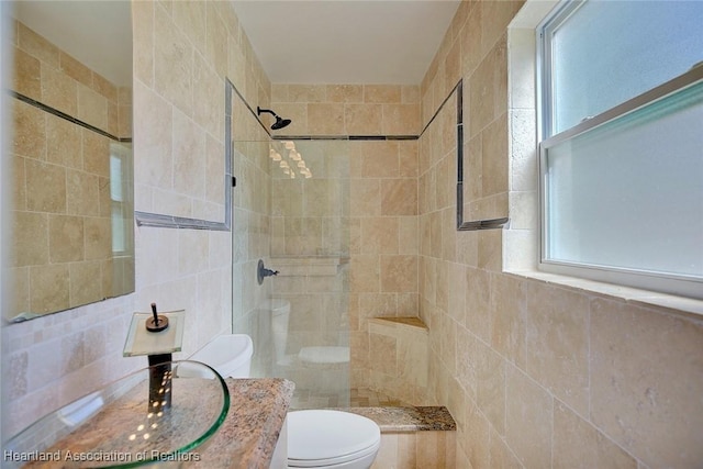 bathroom with tiled shower, vanity, and toilet