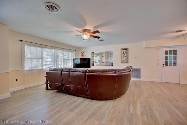 living room with ceiling fan and light hardwood / wood-style flooring