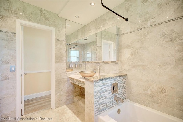 bathroom featuring sink, tile walls, and washtub / shower combination