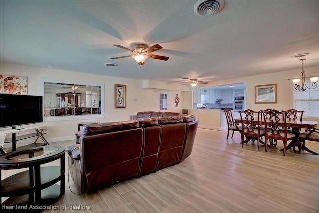 living room with a chandelier and light hardwood / wood-style floors