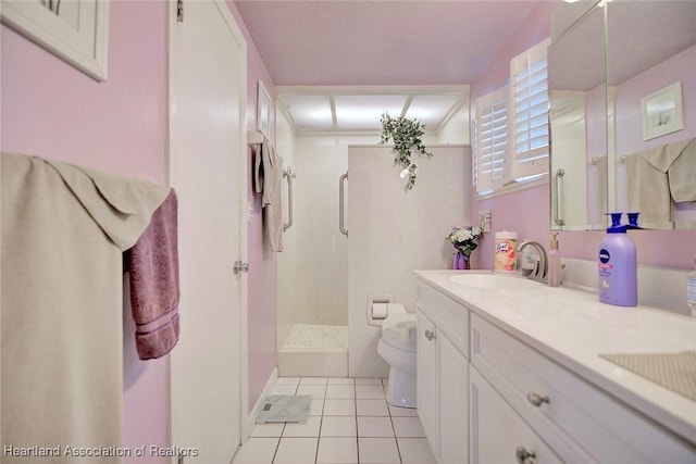 bathroom with tile patterned flooring, vanity, a shower, and toilet