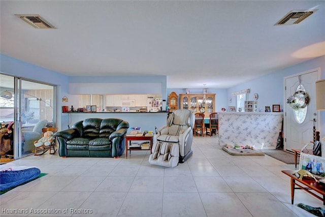 living room with light tile patterned flooring and an inviting chandelier