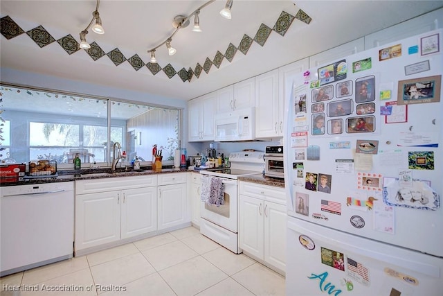 kitchen with white cabinetry, sink, white appliances, and light tile patterned floors