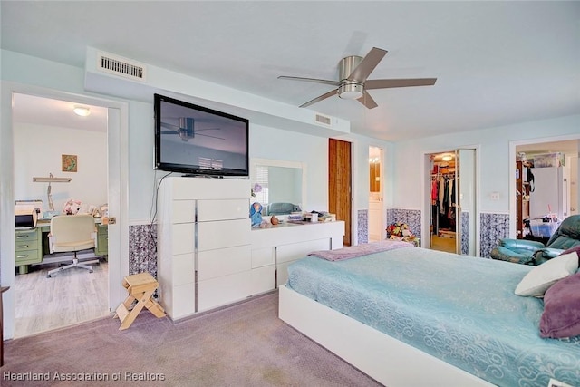 bedroom with ensuite bath, carpet flooring, ceiling fan, and a spacious closet