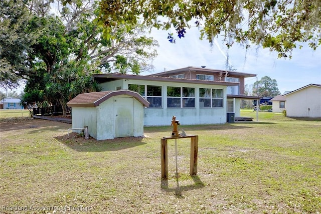 rear view of house with a sunroom, central AC unit, and a lawn