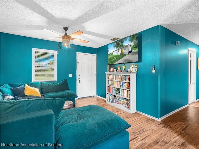 1802 W Fondulac Rd, Avon Park, FL 33825 - living room with a textured ceiling, ceiling fan, wood finished floors, and baseboards