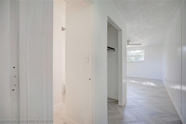 hall with a textured ceiling and light parquet flooring