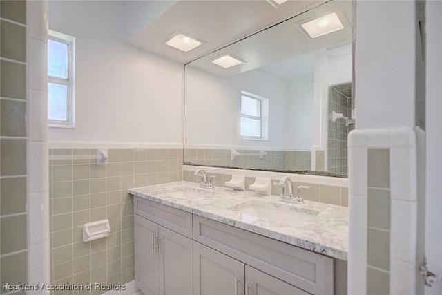 bathroom with vanity and tile walls