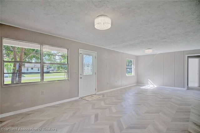 empty room featuring a textured ceiling and light parquet flooring