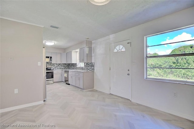 kitchen with appliances with stainless steel finishes, backsplash, light parquet floors, and sink