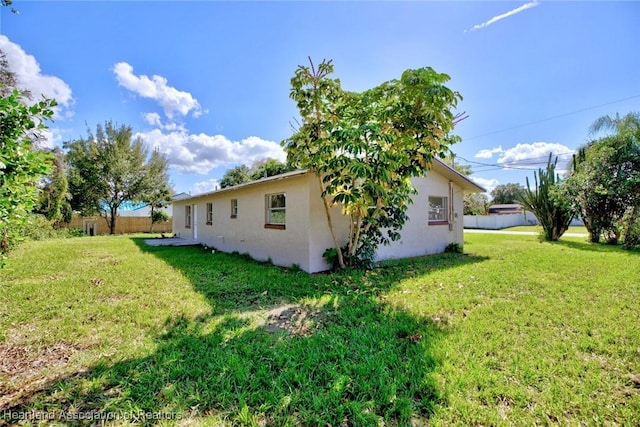 view of side of home with a yard