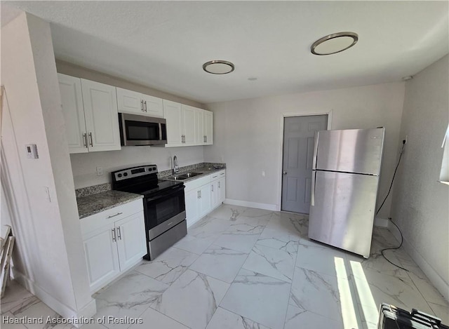 kitchen featuring white cabinets, appliances with stainless steel finishes, and sink