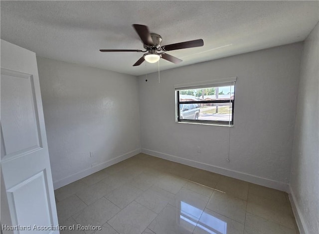 unfurnished room with ceiling fan and a textured ceiling