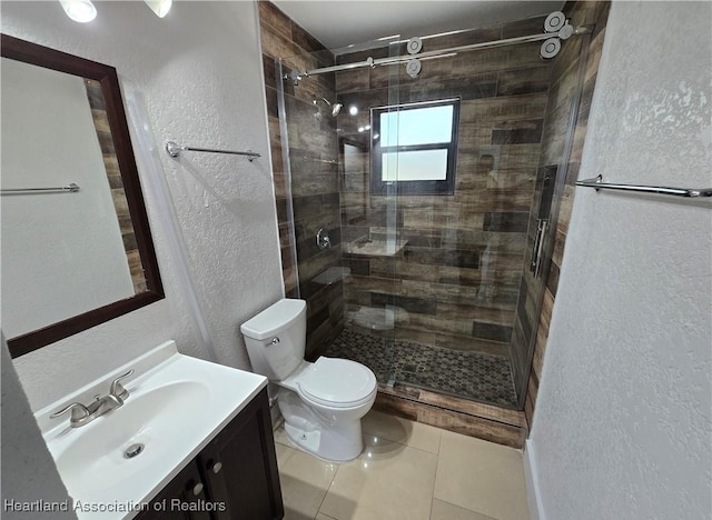 bathroom featuring tile patterned flooring, vanity, an enclosed shower, and toilet