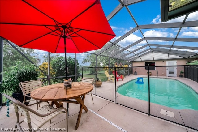 view of pool featuring glass enclosure and a patio