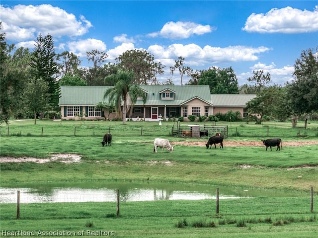 view of community featuring a yard, a water view, and a rural view