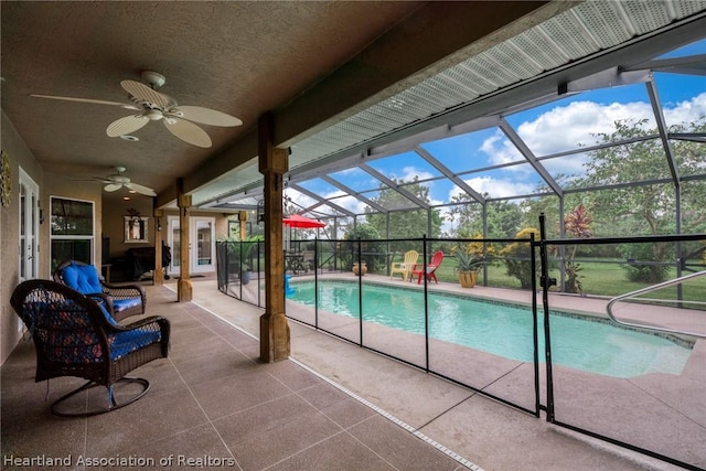 view of pool featuring a lanai, a patio area, and ceiling fan