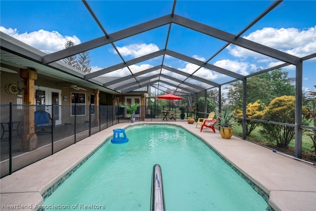 view of swimming pool featuring french doors, a patio area, ceiling fan, and a lanai