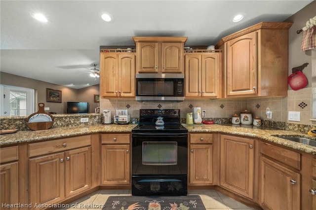 kitchen with backsplash, electric range, light tile patterned floors, and light stone countertops