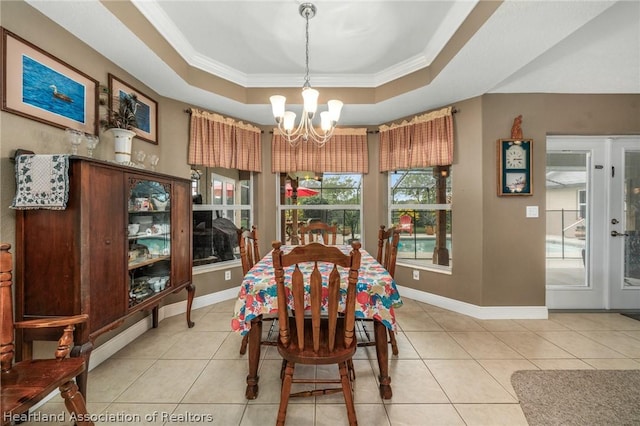 dining area featuring light tile patterned floors, ornamental molding, and a tray ceiling