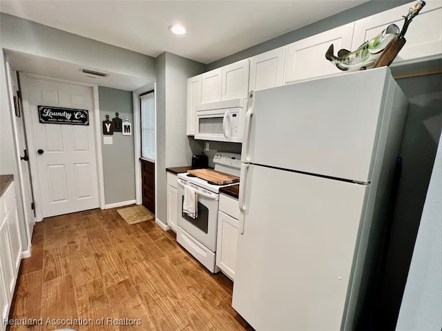 kitchen featuring white appliances, visible vents, light wood-style floors, white cabinets, and dark countertops