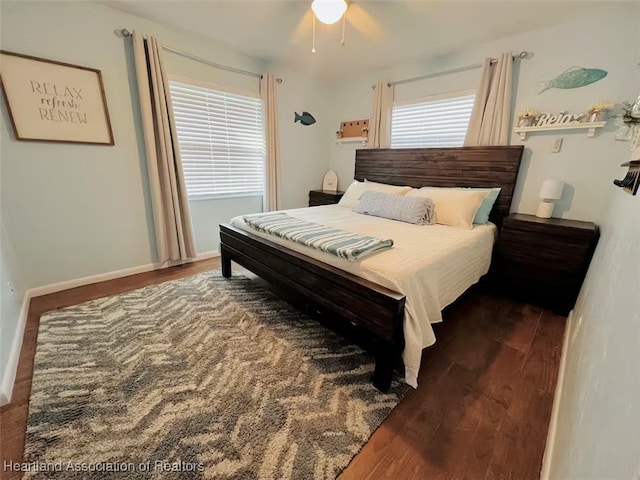 bedroom with dark wood-type flooring, ceiling fan, and baseboards