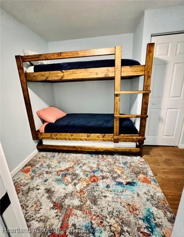 bedroom with wood finished floors and baseboards