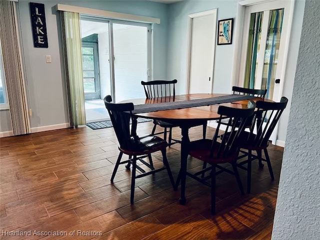 dining space featuring dark wood-style floors and baseboards