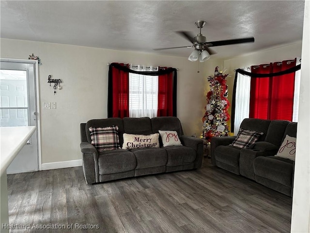 living room with ceiling fan and dark wood-type flooring