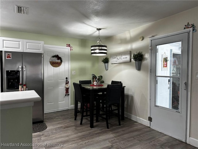 dining space featuring dark hardwood / wood-style flooring and a textured ceiling