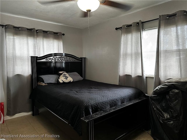 tiled bedroom with multiple windows and ceiling fan