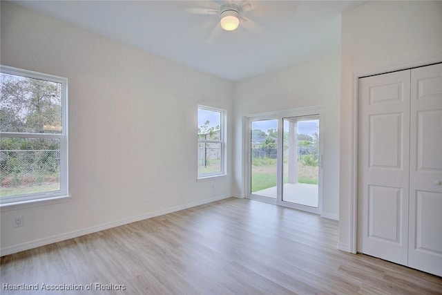 spare room with baseboards and light wood-type flooring