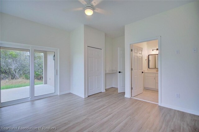 unfurnished bedroom with connected bathroom, baseboards, light wood-type flooring, a ceiling fan, and access to outside